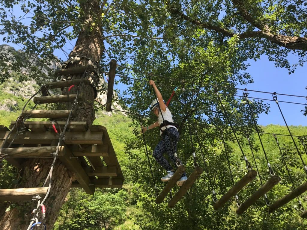 Ragazza sospesa su una zip line sopra il fiume Sentino al Parco Frasassi Avventura